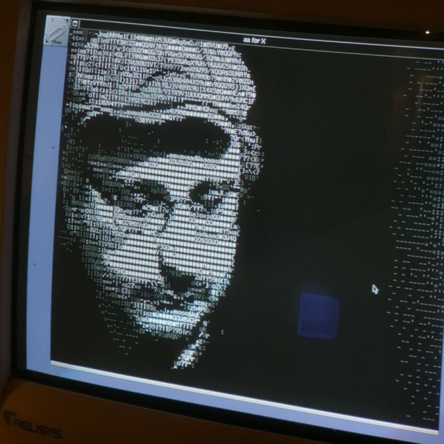 ritratto di enrico bisenzi alias ferry byte con cappello occhiali e baffi in stile ascii art mentre osserva del codice informatico che si sviluppa davanti a se